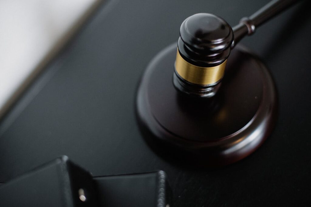 Close-up of a wooden judge's gavel on a black desk, symbolizing justice and law.